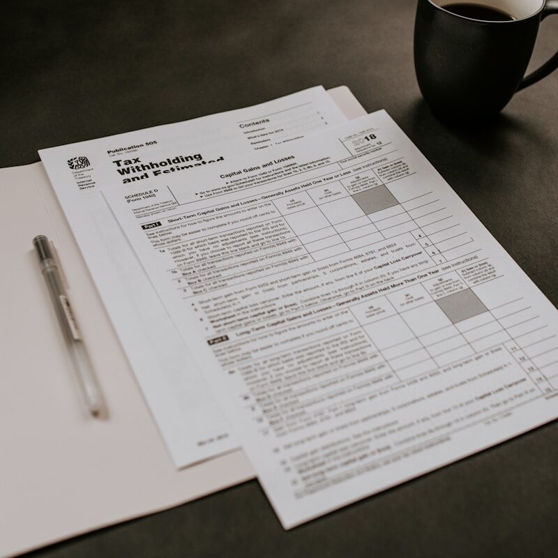 black ceramic mug beside white printer paper